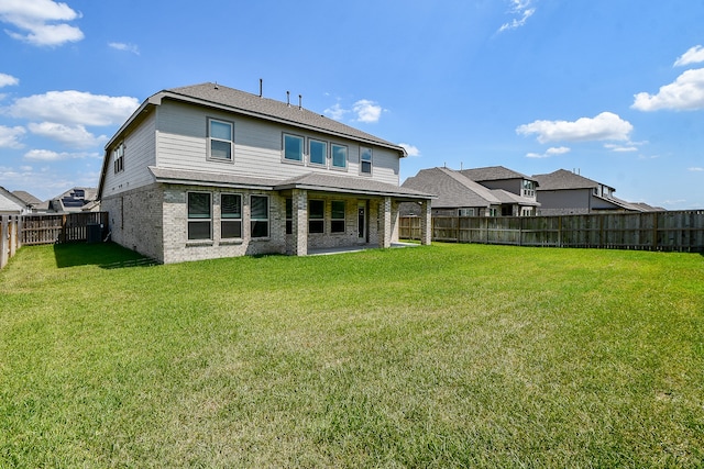 back of house featuring a patio area and a yard