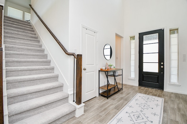 foyer entrance featuring light wood-type flooring and a high ceiling