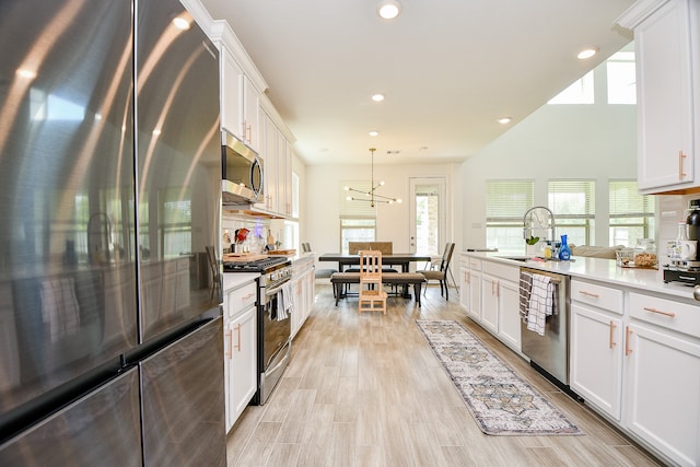 kitchen featuring white cabinetry, a wealth of natural light, sink, and stainless steel appliances