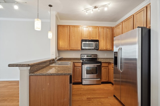 kitchen featuring sink, rail lighting, kitchen peninsula, and appliances with stainless steel finishes