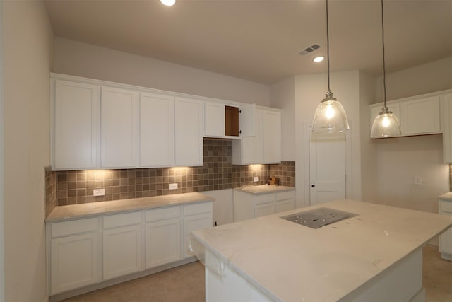 kitchen featuring decorative light fixtures, a kitchen island, and white cabinets