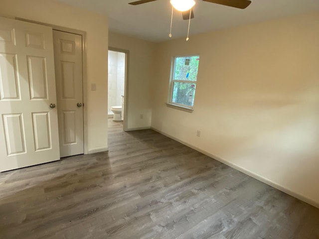 626 Hines Rd, Point Blank, TX 77364 - unfurnished bedroom featuring baseboards, wood finished floors, ensuite bath, and a ceiling fan
