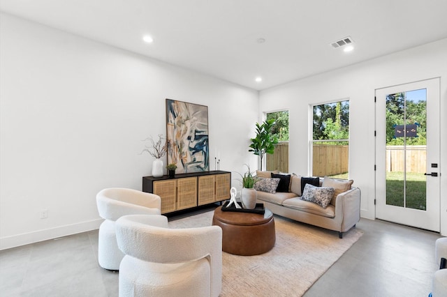 living room with baseboards, visible vents, and recessed lighting