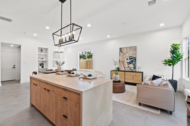 kitchen with built in shelves, modern cabinets, visible vents, and a center island