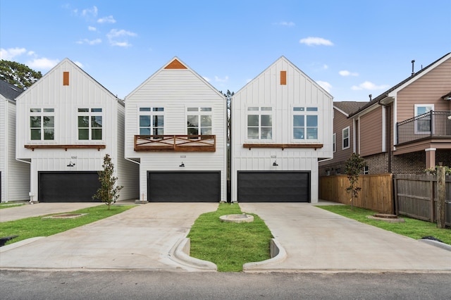 view of front facade featuring board and batten siding, fence, and a garage