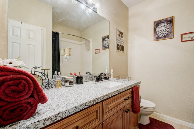 bathroom with toilet, baseboards, a shower with shower curtain, and vanity