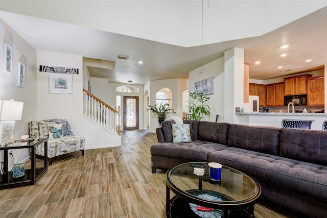 living room featuring recessed lighting, visible vents, baseboards, stairway, and light wood finished floors