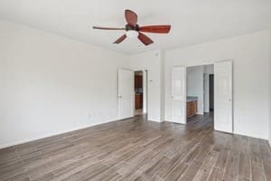 empty room featuring dark wood-type flooring and ceiling fan