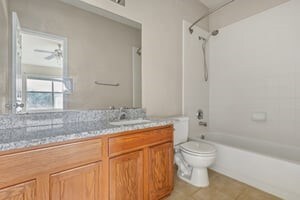 full bathroom featuring shower / bathtub combination, tile patterned floors, vanity, toilet, and ceiling fan