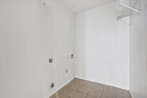 clothes washing area with laundry area, tile patterned flooring, and electric dryer hookup