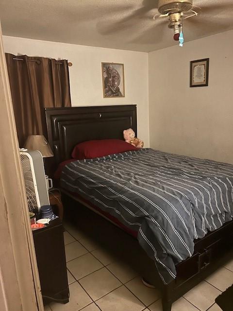 5211 Pensdale, Houston, TX 77033 - bedroom with light tile patterned flooring, ceiling fan, and a textured ceiling