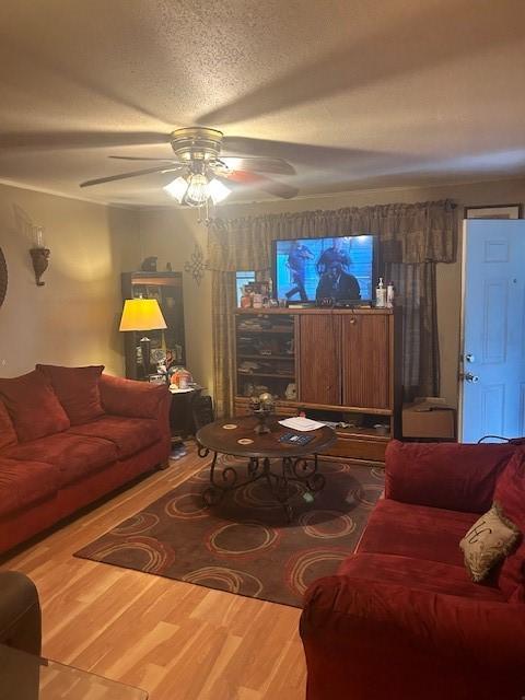 5211 Pensdale, Houston, TX 77033 - living room featuring a textured ceiling, wood finished floors, and a ceiling fan