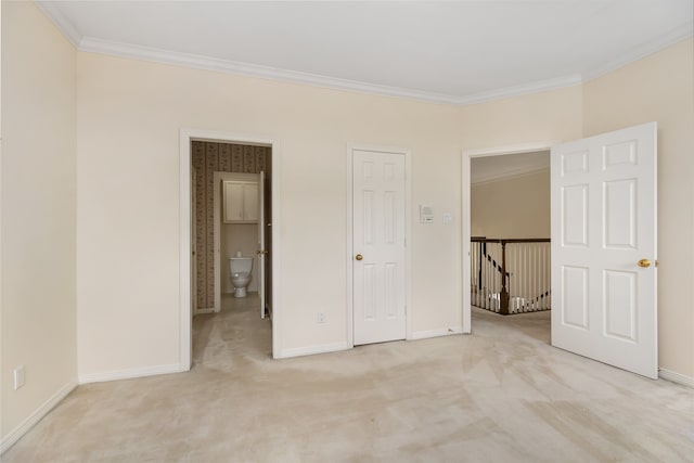 unfurnished bedroom with crown molding, light colored carpet, and ensuite bath