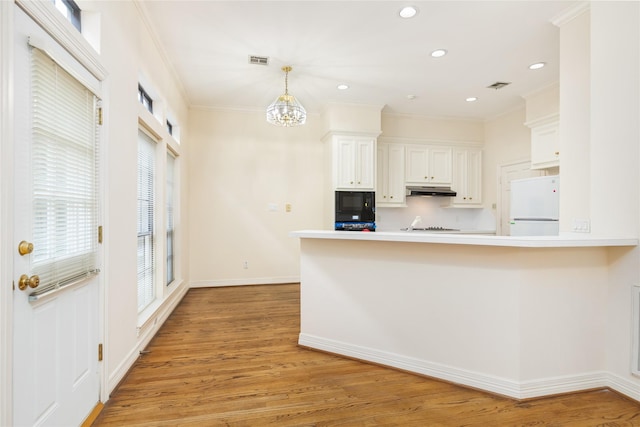 kitchen featuring white cabinetry, tasteful backsplash, light hardwood / wood-style flooring, kitchen peninsula, and black appliances