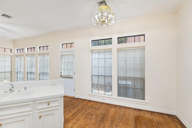 bathroom featuring hardwood / wood-style flooring, ornamental molding, and sink