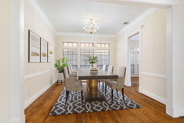 dining area featuring ornamental molding, dark hardwood / wood-style floors, and a chandelier