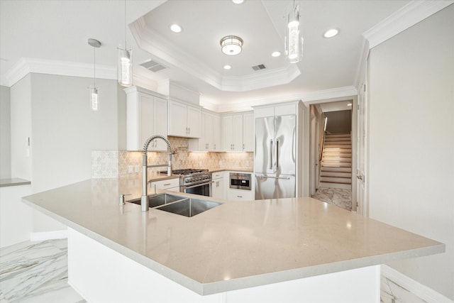 kitchen featuring high end appliances, a raised ceiling, a peninsula, marble finish floor, and a sink