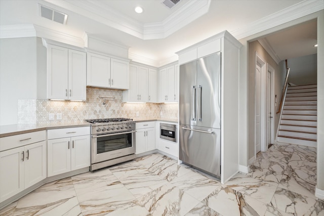 kitchen featuring tasteful backsplash, built in appliances, crown molding, and light tile patterned floors