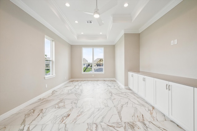 tiled empty room with ceiling fan, a raised ceiling, and crown molding