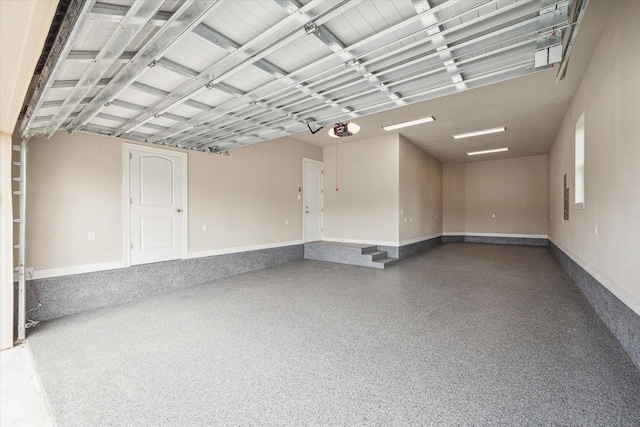 garage with a garage door opener and baseboards