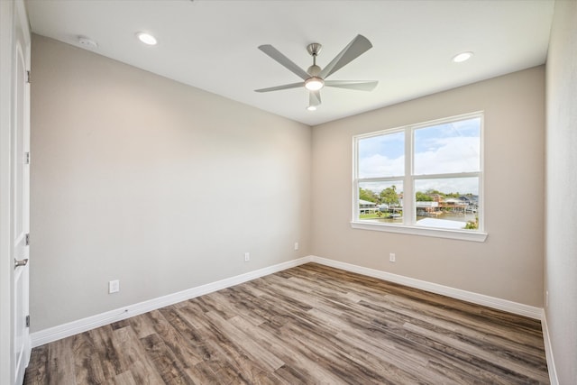 empty room with ceiling fan and hardwood / wood-style flooring