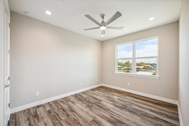 unfurnished room with recessed lighting, wood finished floors, a ceiling fan, and baseboards