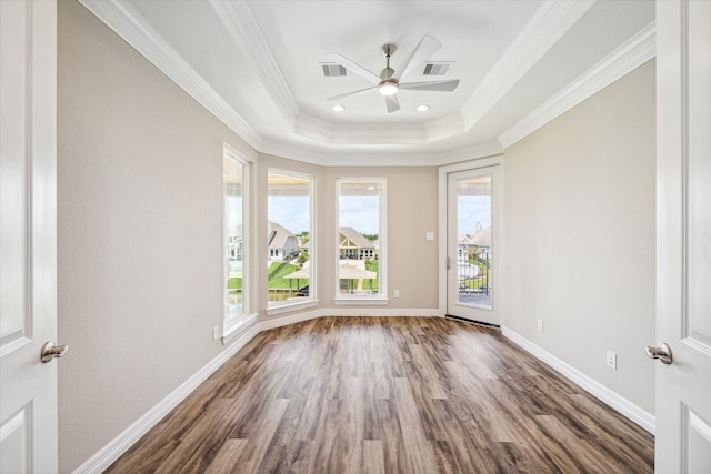 unfurnished room featuring a tray ceiling, ceiling fan, crown molding, and dark hardwood / wood-style floors