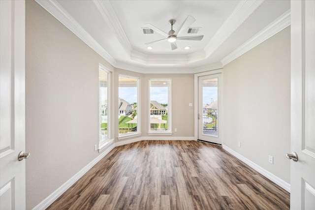 unfurnished room with baseboards, visible vents, crown molding, and wood finished floors