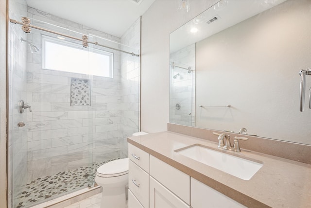 bathroom featuring tile patterned flooring, vanity, walk in shower, and toilet