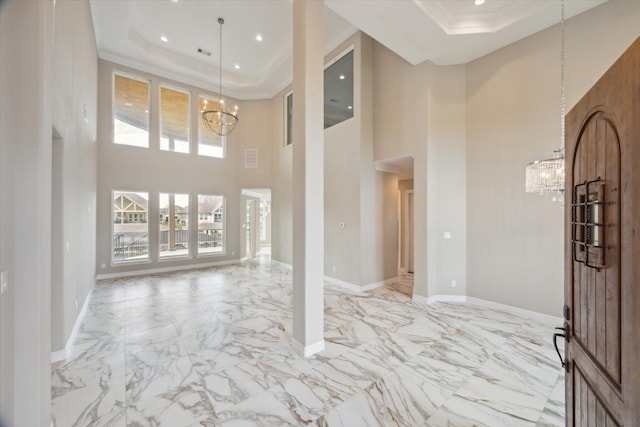 502 Amalfi Dr, Kemah, TX 77565 - entrance foyer featuring a chandelier, a raised ceiling, light marble finish flooring, crown molding, and a high ceiling