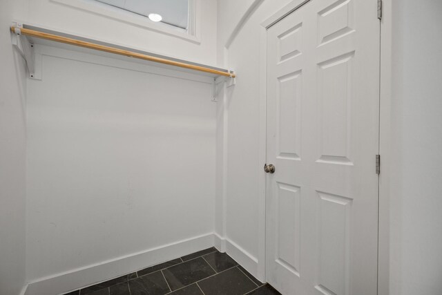 spacious closet featuring dark tile patterned flooring