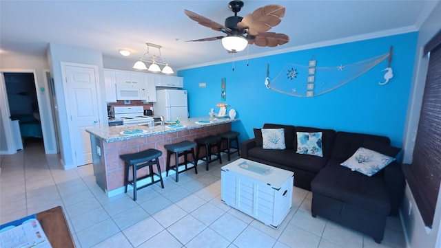 living area featuring light tile patterned floors, ornamental molding, and a ceiling fan