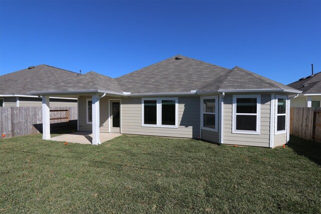 rear view of house featuring a yard and a patio