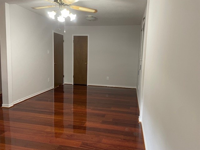 empty room featuring dark hardwood / wood-style flooring and ceiling fan