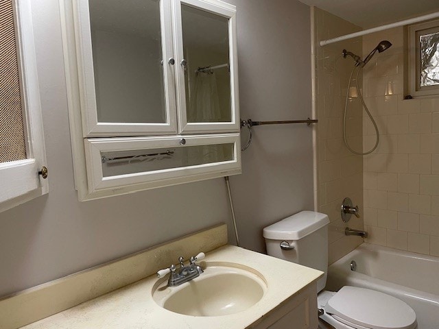 full bathroom featuring toilet, tiled shower / bath combo, and vanity