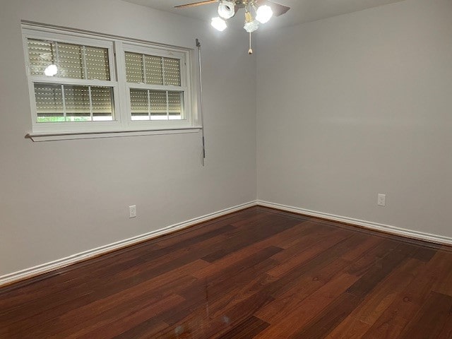 spare room featuring dark hardwood / wood-style flooring and ceiling fan