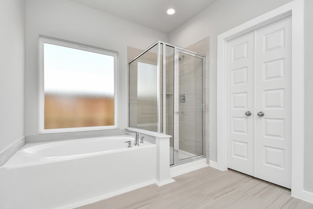 bathroom with tile patterned flooring and separate shower and tub