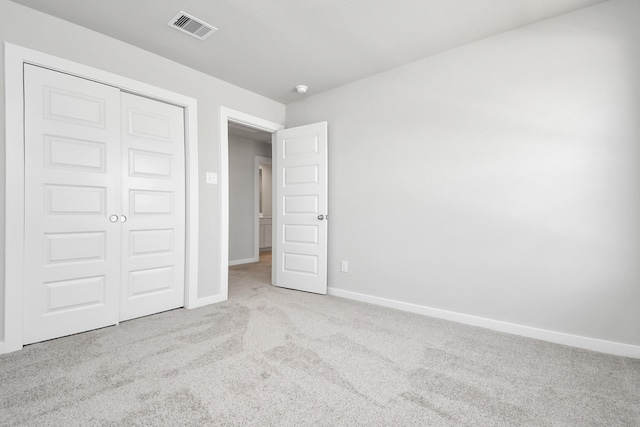 unfurnished bedroom with a closet and light carpet