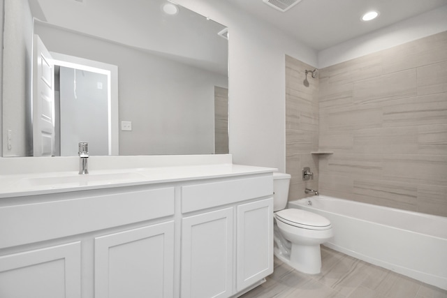 full bathroom with tile patterned floors, vanity, tiled shower / bath combo, and toilet