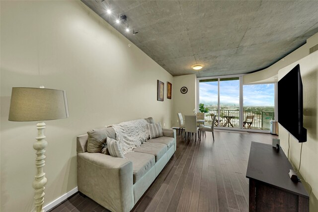 living room featuring rail lighting, floor to ceiling windows, and dark hardwood / wood-style flooring