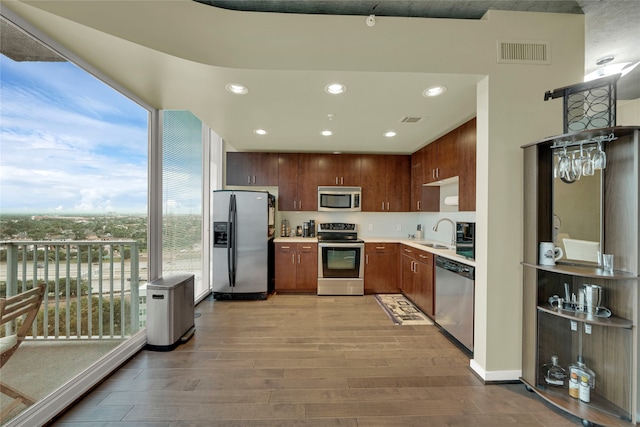 kitchen with light hardwood / wood-style flooring, stainless steel appliances, and sink