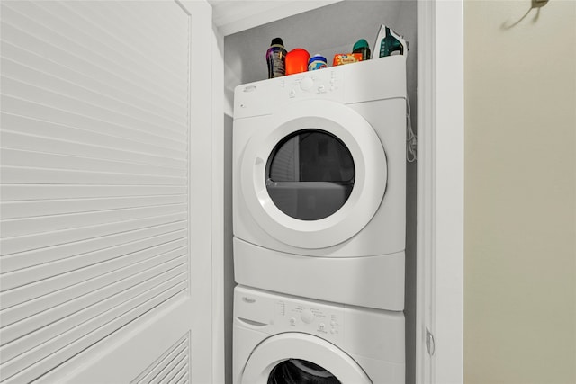 clothes washing area featuring stacked washing maching and dryer