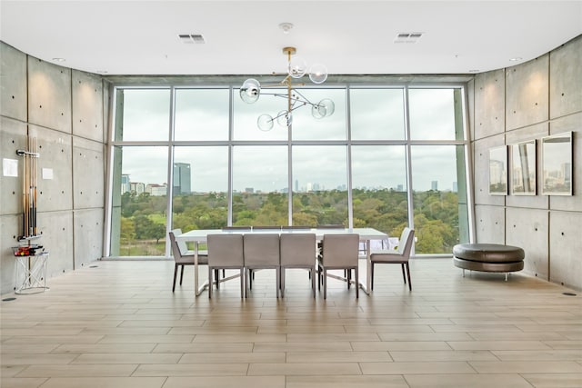 dining space with light hardwood / wood-style flooring, floor to ceiling windows, and an inviting chandelier