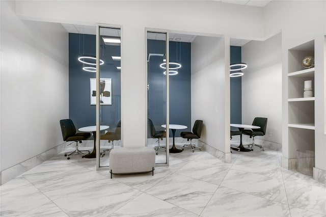 living area featuring built in shelves, a high ceiling, and light tile patterned floors