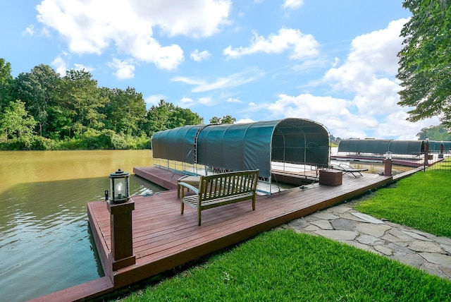 view of dock with a lawn and a water view