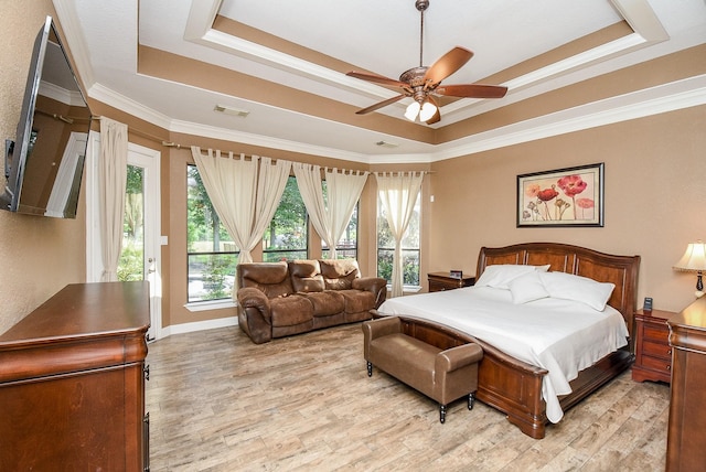 bedroom with light wood-type flooring, a raised ceiling, ornamental molding, and ceiling fan