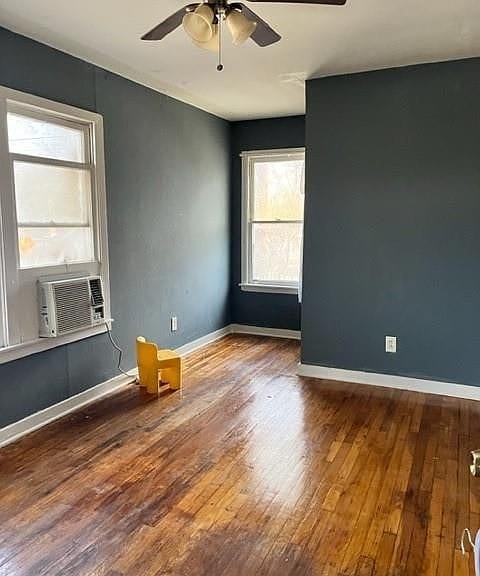 2410 Milby St, Houston, TX 77004 - unfurnished room with a ceiling fan, cooling unit, baseboards, and wood finished floors
