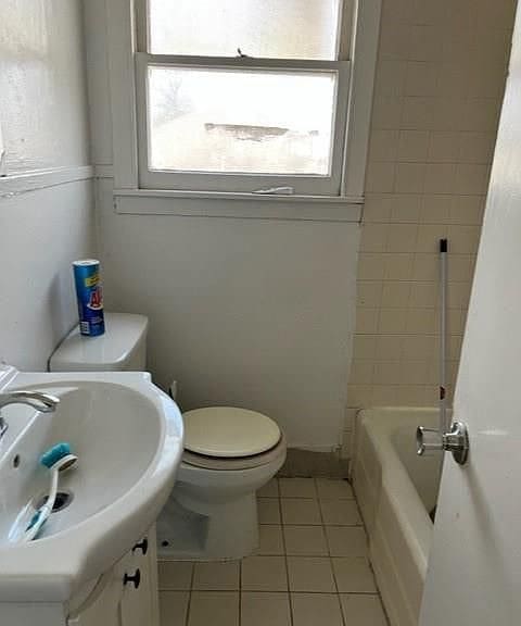 full bathroom with toilet, a healthy amount of sunlight, independent shower and bath, and vanity