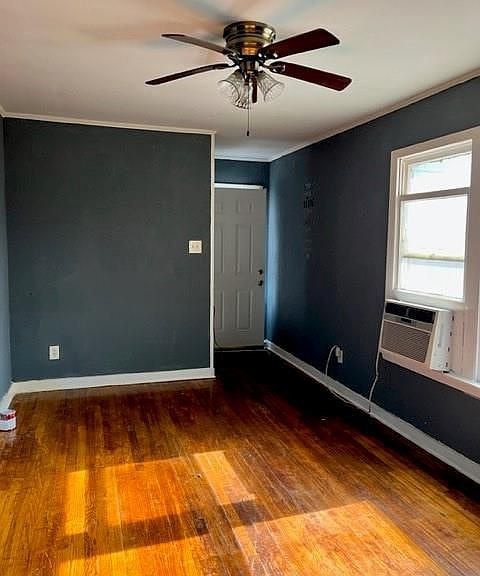 empty room with ceiling fan, cooling unit, and dark hardwood / wood-style floors