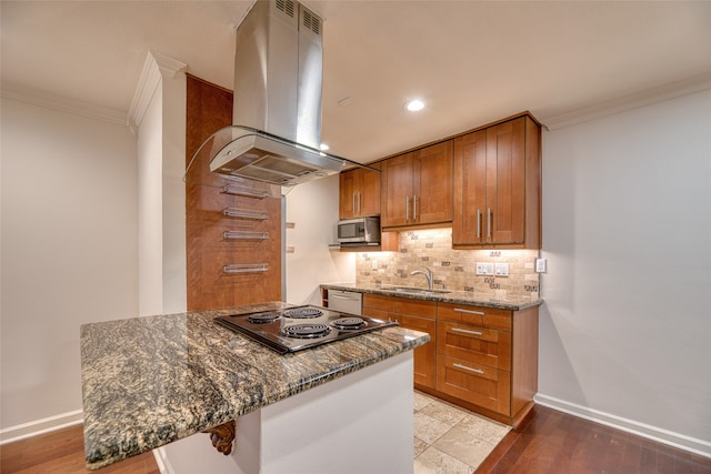 kitchen with island range hood, dark stone countertops, light hardwood / wood-style flooring, and sink